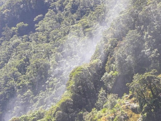 The spray from the waterfall comes over the ridge on the side.