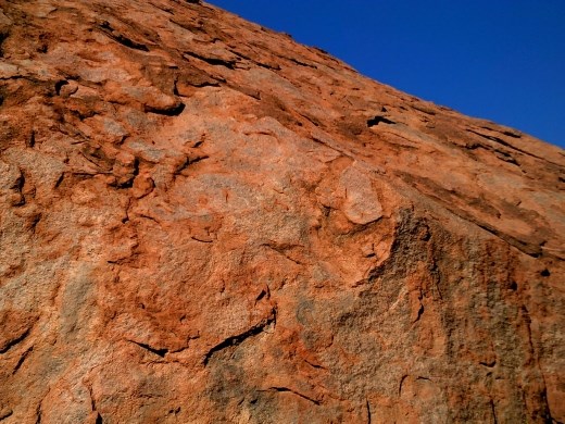 From even a short distance, Uluru's surface looks smooth. But when you get close, you see how rough it is. It's been scoured by winds for eons.