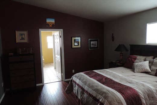 We have this stunning red accent wall in our Master Bedroom. The small painting above the doorway depicts sunflowers, which we bought in San Marino. The prints on either side of the doorway show street scenes from Lisbon, Portugal. The black and white print on the far right shows the village of Barga, Italy, rising out of the fog. On the extreme right, you can see a wooden Maori war club that we bought in Christchurch, New Zealand.