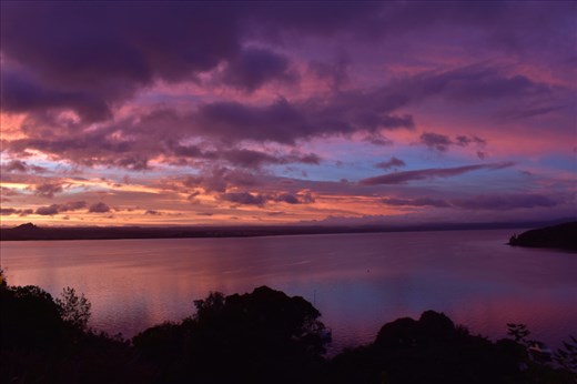 Fiery clouds are reflected in the still waters of Lake Taupo.