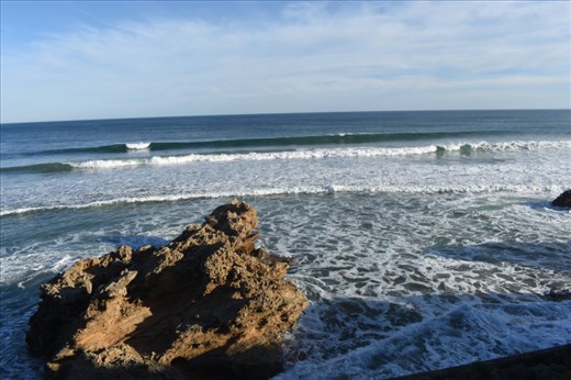 The 2nd wave just begins to break as the 1st wave rolls noisily onto the shore.