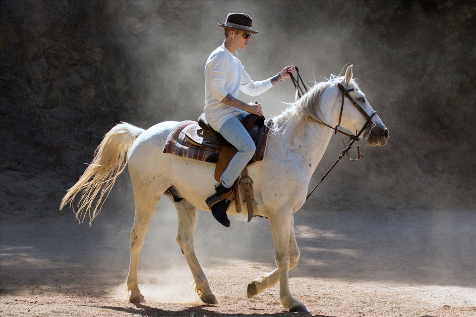 Justin Bieber riding a horse in the hills, escaping the pressure of Hollywood.
