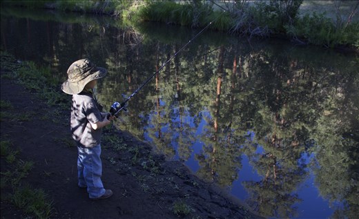 The Hunt. Six-year-old Mason patiently waits for something to bite his bait along the Black River. This is his first time fishing. 