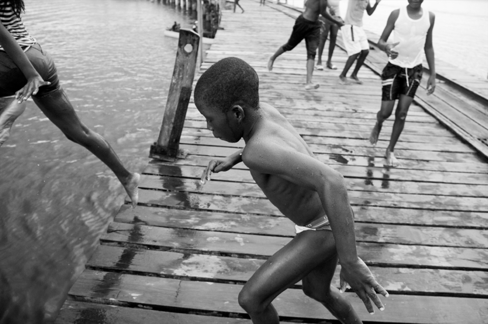 Children are everywhere. Many are sent to school during the day, others do not attend school and spend their time playing and swimming at the dock. On the warmest of days, the dock is slick with water as youngsters take turns launching themselves into the water below.