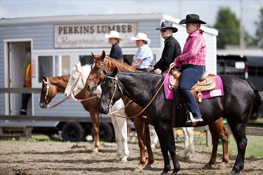 Four riders wait for their turns in an equestrian competition at the 2012 Richmond Fair, an annual festival that celebrates agriculture in the greater Ottawa community.