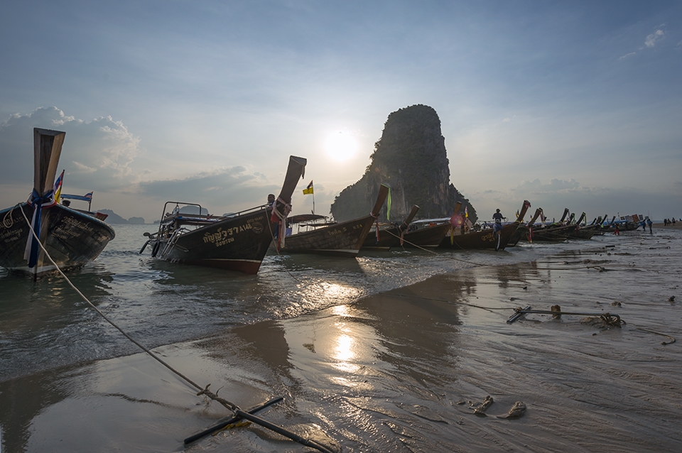On Railay Beach in Thailand with a string of cooking boats!