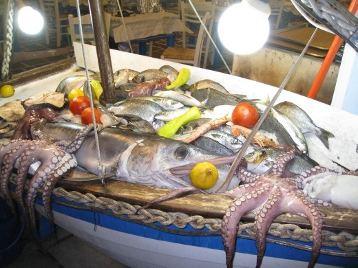 Fresh fishes and differents kinds of sea inside the boat is advertisement to attract tourists in a traditinal restaurant in the town of Naxos