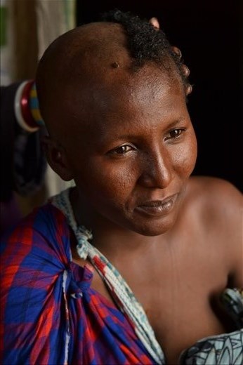 Mother’s blessing.
She is Señorita, her mother-in-low is cutting her hair. Maasai use to have very short hair.