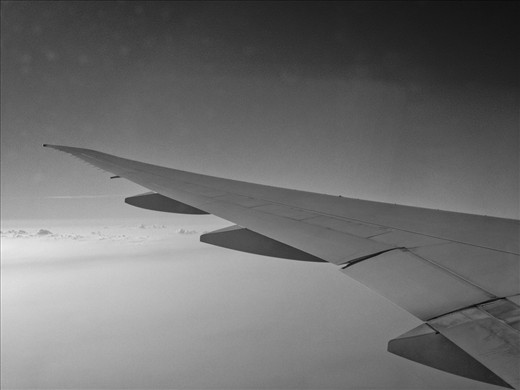 Flying home sweet home - Inside the flight,  the wing of the aircraft flying above clouds  taking everyone home