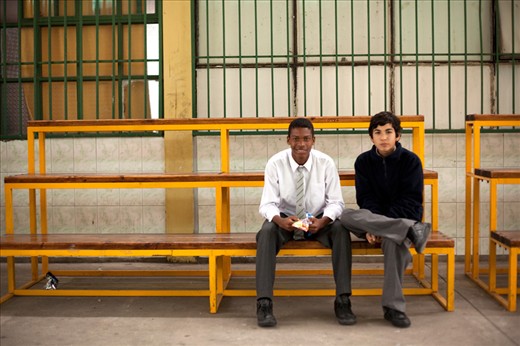 Two Chilean school kids pose for a photo on the edge of the school quadrangle.