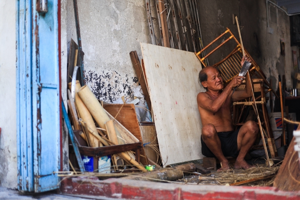 This is Mr. Soon's narrow workspace. Sharp work and a very discipline man, Mr. Soon carefully takes on the trade 6 days a week and live upstairs. He is slicing down the bamboo at equal width, to then weave to become a round bamboo divider that is going to be placed in the Dim Sum steamer - this is for his client, Cantonese Dim Sum restaurant. Back of him, is the iron grill door, torn down from his house when his house caught on fire last year, that forced the firemen to cut his grill door to do fire rescue. Thank God he was safe. Today, he still keeps it and hope to reinstall back; but we know it will never happen. You shall know why in the last photo.