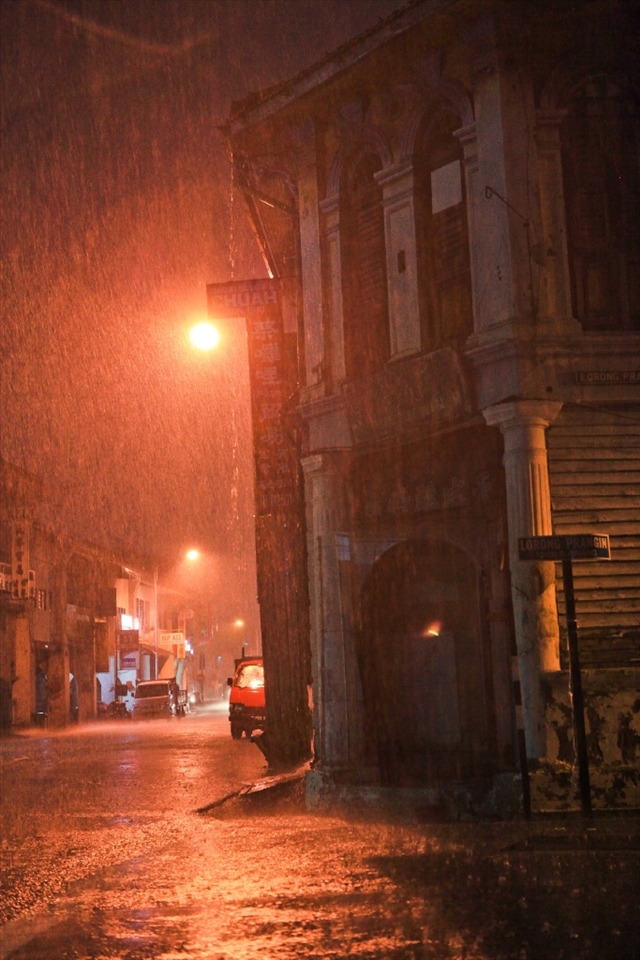 Rainy night at Mr. Soon's rented family home and workplace. His family generations have been staying here for the past 120 years. Life here however is coming to an end for Mr. Soon and his family by December 2014. With the once famous British colonial trading settlement - George Town rapidly turning into tourist town after the conferment of UNESCO title in 2008, he is not spared from merciless home eviction due to capitalism. Even being listed in the intangible heritage trade inventory, Mr. Soon today is facing the threat of not having a place to run his old trade, as the rental price tag has skyrocketed to an unrealistic figure, that poses so much threat to his already endangered trade - the bamboo and rattan weaver trade. He is contemplating to stop his old trade, not because of the lack of business volume, but basically involuntary movement (without any protection and relocation effort from UNESCO official monitoring agency) and high rental for alternative place. The gentrification of tourism has caused ripple effect of lacking of workplace for traditional trade and residence for the living heritage. Food for thought. We hope this series of documentary photos give us room to think, how could we make the photos meaningful and to help the community at large.