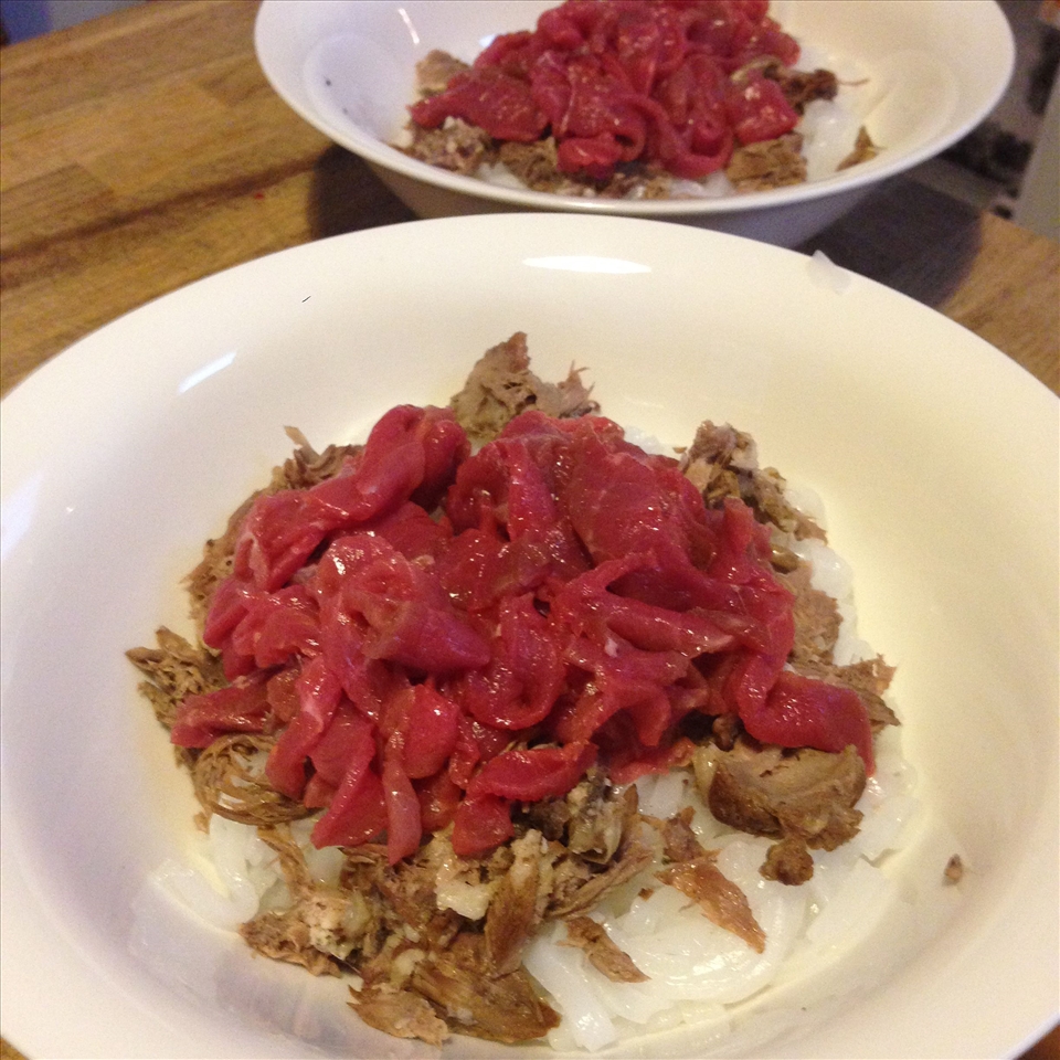 Raw beef and meat off the bone on top of noodles.