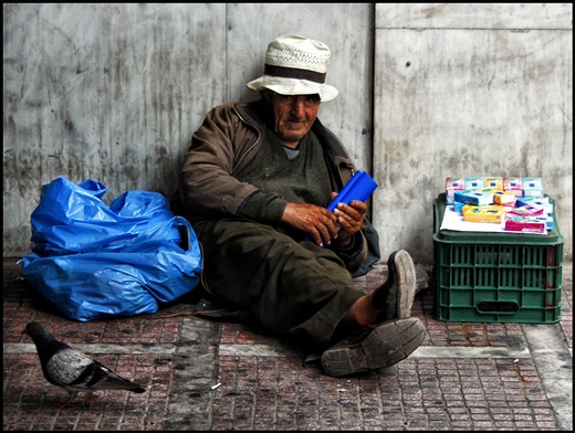 - A homeless elderly trying to survive by selling tissues in a central street of Athens with single companion, pigeons and a notebook of his poems ..