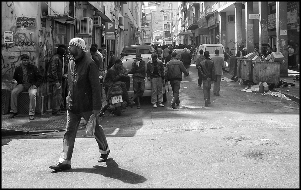 A central street of Athens has turned into crowded ghetto, where hundreds of immigrants who came to Greece for a better life, face the decline .. Somewhere a Greek flag reminds us where we are ..