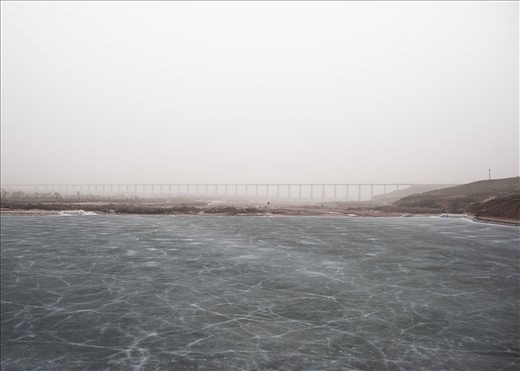 Middle of no where.
Iced lake and behind, a huge under construction bridge.