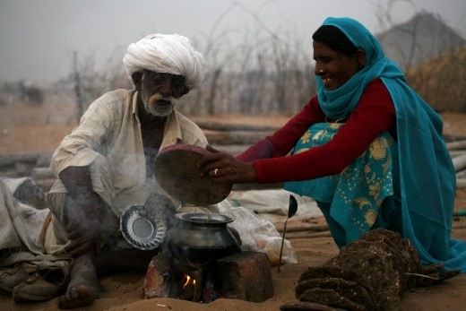 A Trader with his wife cooking dinner in the open field. In the evening you can see all over the trading field make shift 'Choolah' (cooking stove). Some traders come with their wives and few come with their friends but most of them cook their own food.