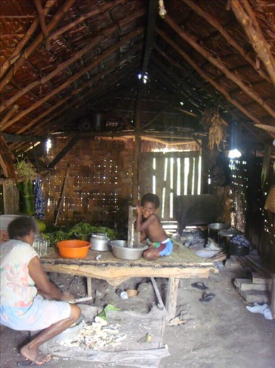 Grandmother and Ashila grinding yams for laplap in the kitchen, Caroline Bay, Malekula.
