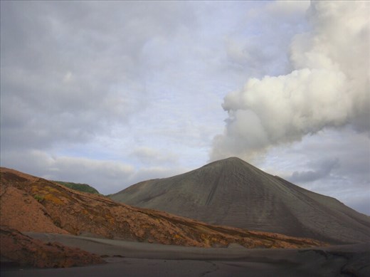 Mt. Yasur behind the red rocks, Tanna.