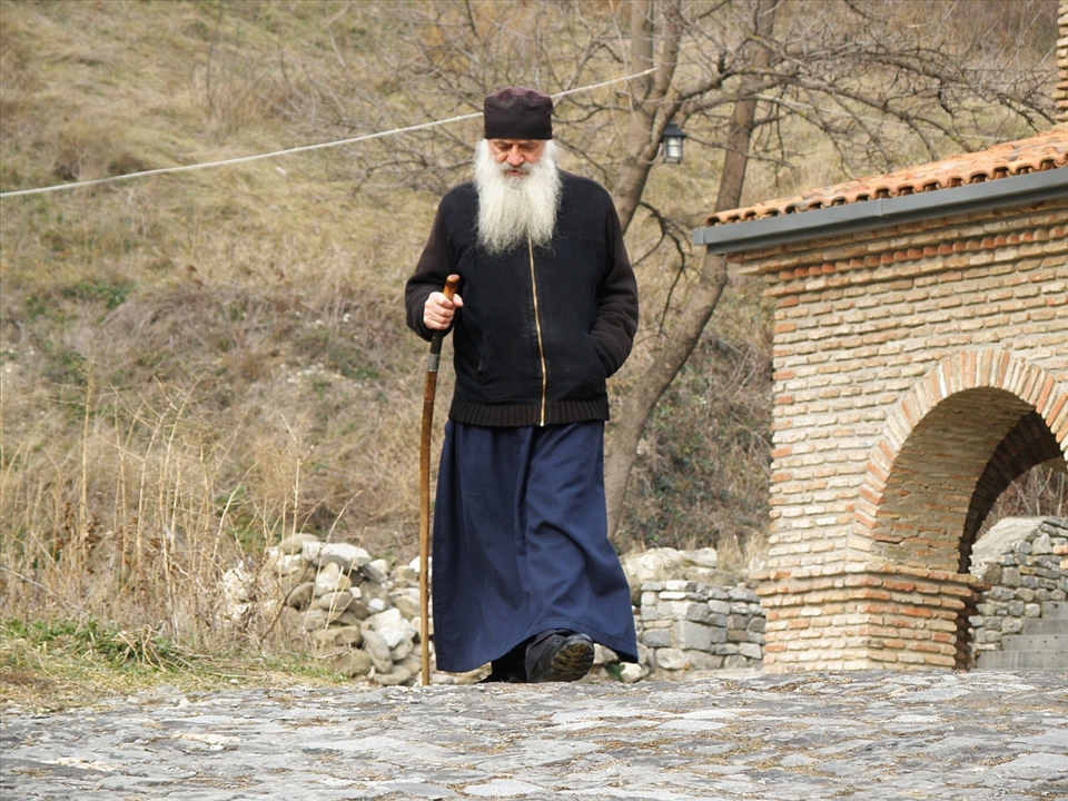 Old monk goes past. Only one small short glance at travellers.