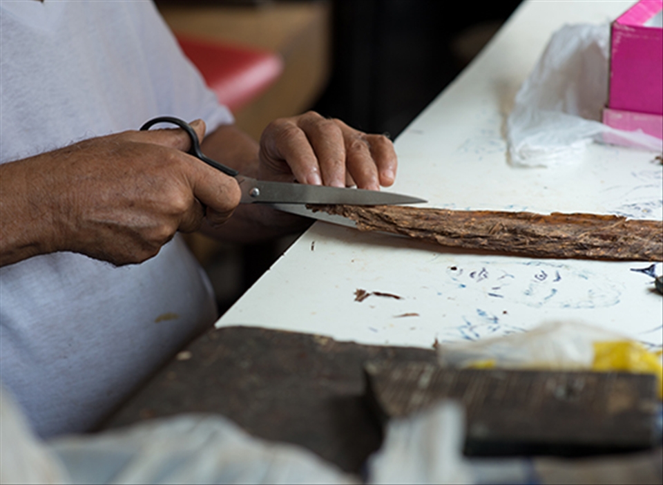 There are ink sketches on the table surface, where he cuts the tobacco.