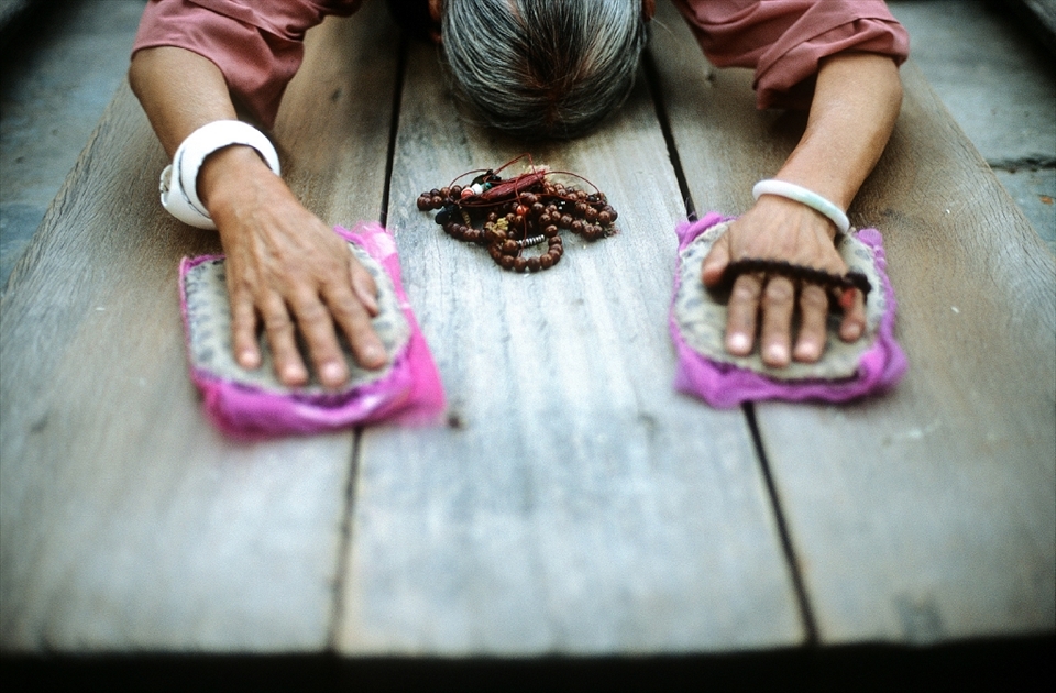 In Tibetan Buddhism prostrations are often performed before meditation or teachings, but can form a separate practice by itself. Prostrations are seen as a means of purifying ones body, speech and mind of karmic defilements, especially pride. Prostrations are used in tandem with visualization and can be used to express reverence to Guru Rinpoche.  A Tibetan pilgrim prostrating in front of the Jokhang Monastery using japa mala (Buddhist prayer beads) for counting. Lhasa, Tibet.