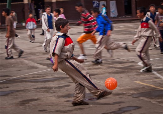 During recess, all of the children at the school swarmed the courtyard to play a complex game of football.