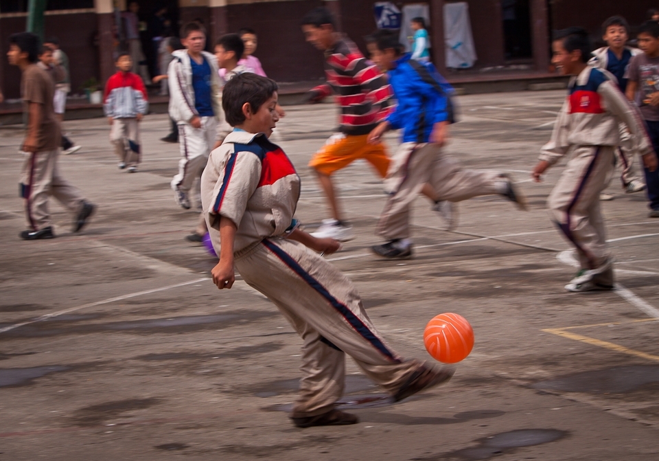 During recess, all of the children at the school swarmed the courtyard to play a complex game of football.