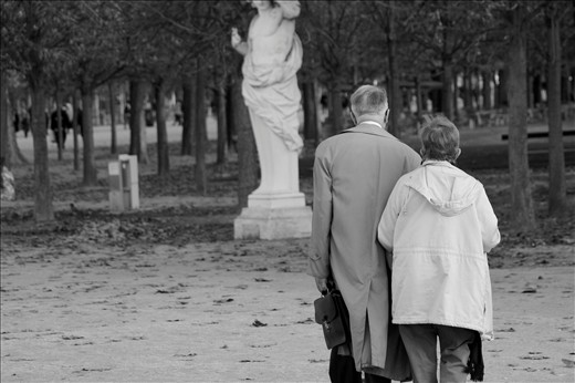The City of Love. An elderly couple walks arm in arm in the city of love. 