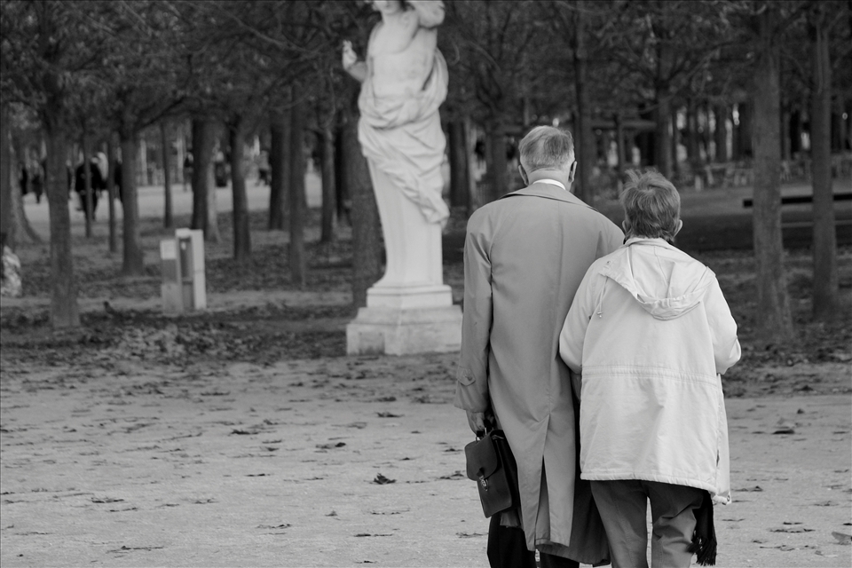 The City of Love. An elderly couple walks arm in arm in the city of love. 
