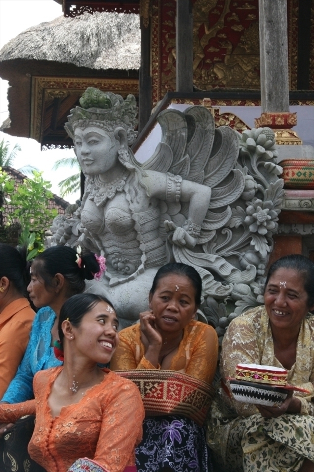 Woman's temple garb, in Balinese Hinduism is typically a bra under a transparent lace jacket, sarong and waist scarf. After temple is a social time.