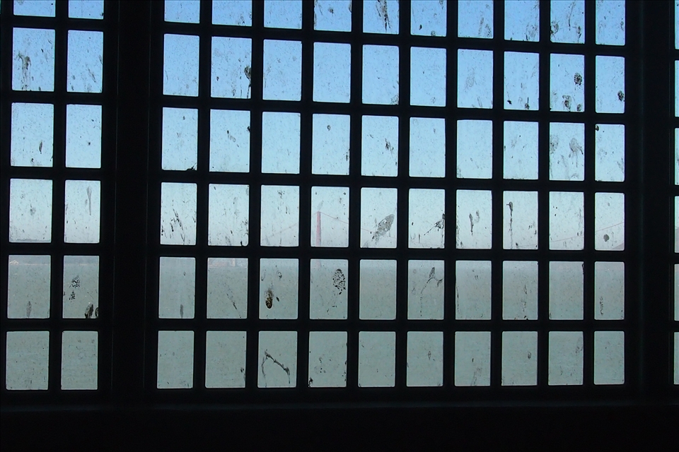 Alcatraz. Freedom. The distant red blur bridge shows through the window bars. 
