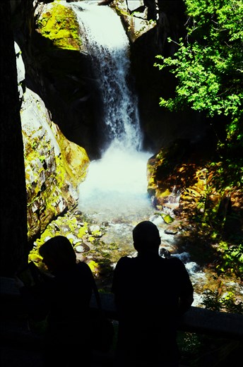 Two people observing a waterfall