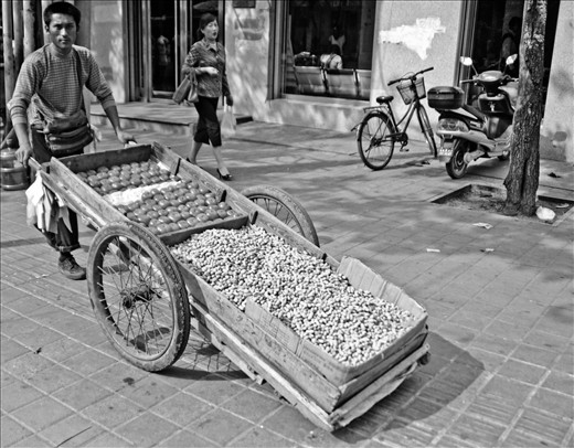 A street vendor walks up and down a main street in Jinan.