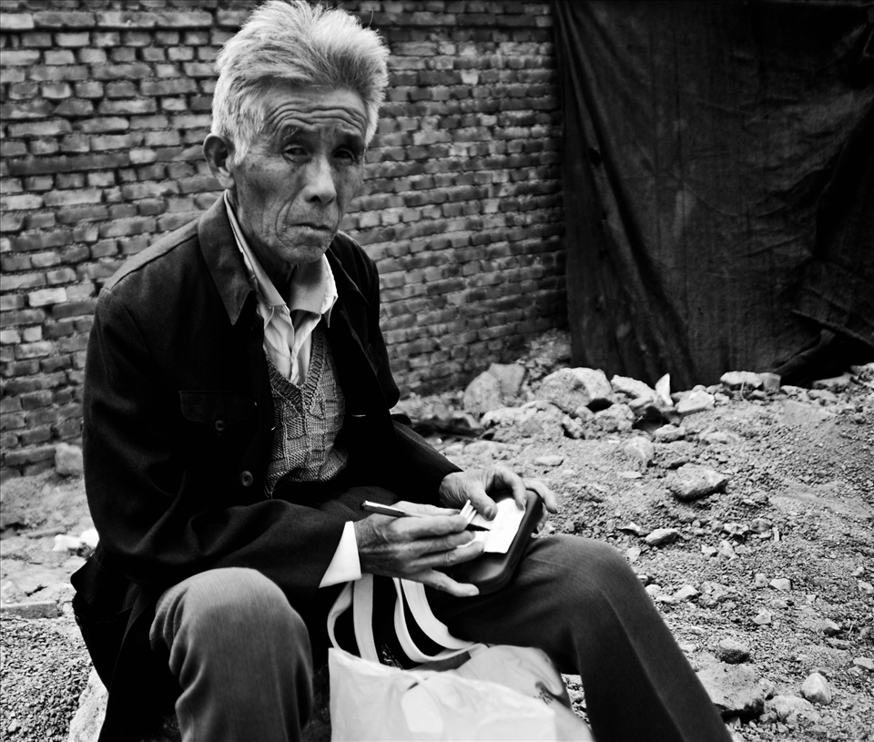 A man who lives in a shack along a main street in Jinan, China.