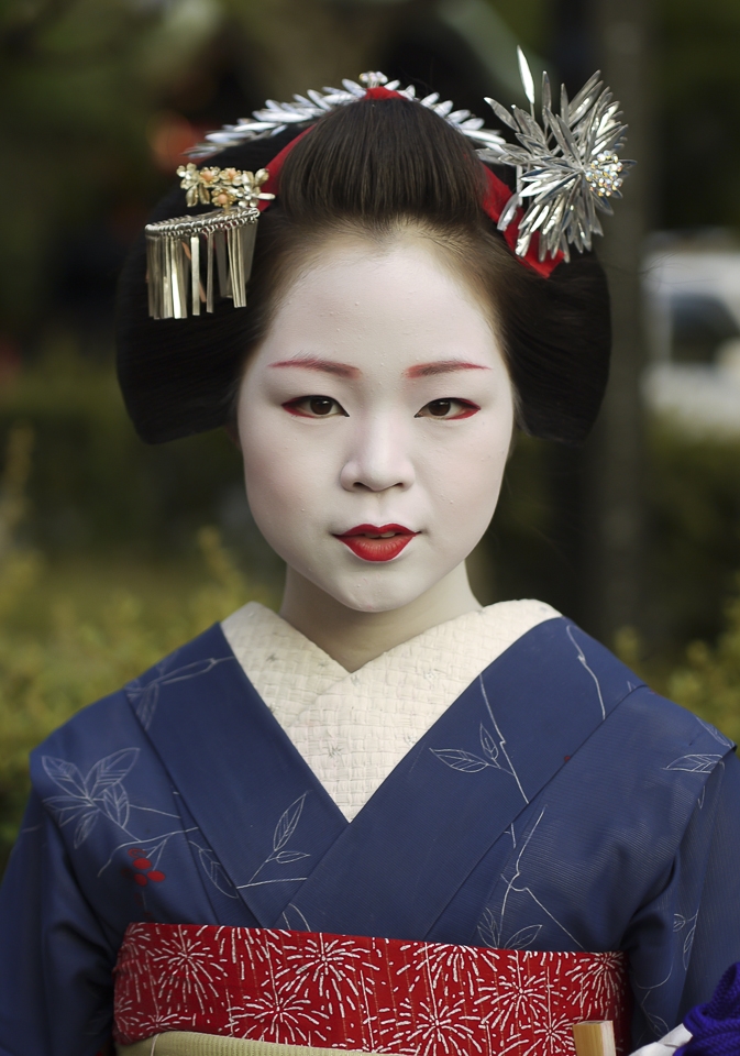 Draped in impossibly elaborate kimono—the most lavish of which can cost upwards of $100,000 USD—and with her face painted porcelain white, catching a glimpse of a maiko as she glides through the worn, well-traveled streets of Gion is akin to gazing upon not a flesh and blood woman, but a ghost. Poised and perfectly put together, geiko and maiko exude elegance and are the living embodiment of centuries of Japanese culture and tradition. So long as they continue to haunt its lanes and alleyways, Gion’s secret histories can endure.