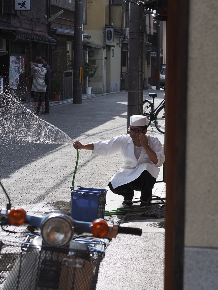 Kyoto, Japan: In the Gion district, a chef washes the pavement in front of his restaurant in preparation for the evening crowds. This age-old tradition continues throughout Japan today, symbolizing that a shop is clean and making it more inviting to passersby. The lazy tranquility that currently enrobes Gion belies the frenetic energy that will soon course down its cobbled lanes, as the neighborhood is one of the few remaining areas where geisha continue to live and work.