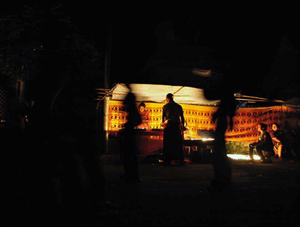 Buddhist Monk takes a detour and lights a candle in worship and goodwill. 