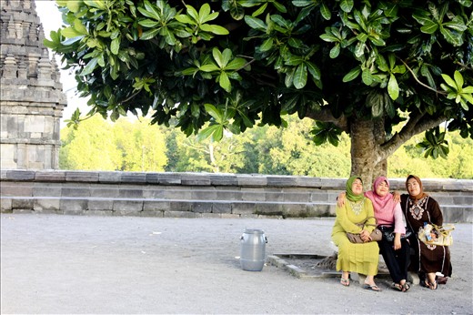 Three local women take a break under a tree after exploring Borobudur temple.