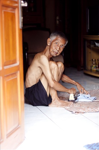 Despite the sweltering heat, a man does his ironing.