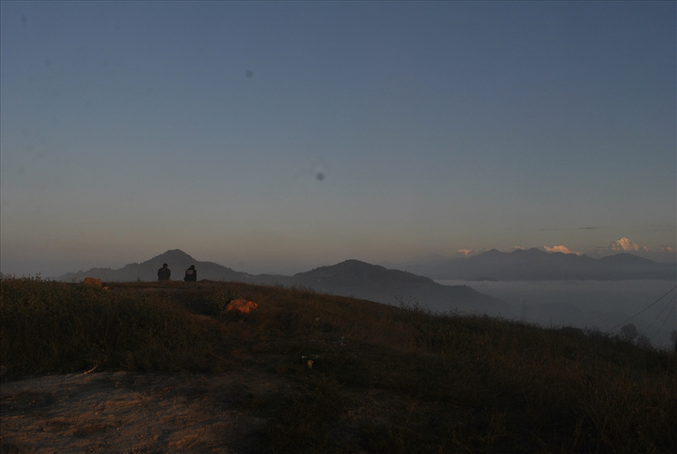 people viewing shining mountains and waiting sun rays to warm up during winter 
