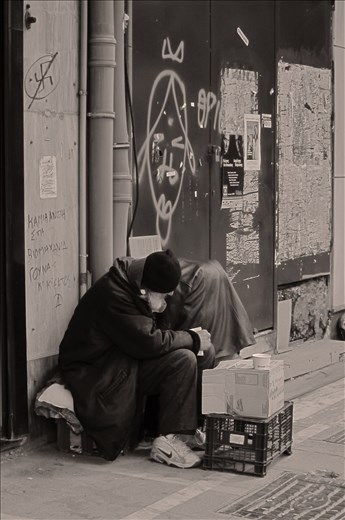 There is still hope in this place. A homeless man doesnt beg only for money but he reads a book something that someone may not expect in such a case. Antifascist symbol written on the wall is another push for our society. 