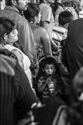 A young boy is playing with a plastic bottle after having been standing in line for over two hours with his family. On October 28 people come from all over the country to visit the Maximon altar in San Andrés Itzapa. Most are Christian. 