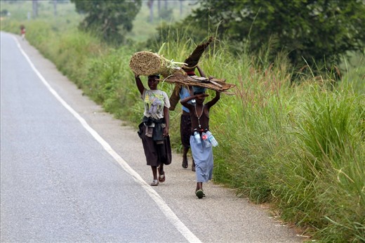 In blistering heat and humidity these young girls carry commodities from their villages across the Nile to sell in the markets.  The cross - A symbol of hope? The bottles - A symbol of survival!