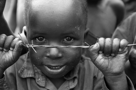 This photo is tells a lot more than what you see at first glance.  From the first moment a child can walk they are necessary in the survival of a family.  This photo speaks of a child held back from many of the things we take for granted. Yet this child looks out beyond this with powerful hands and a penetrating stare.