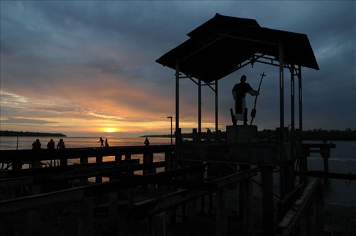 Welcome to Agats. Pastor Jan Smith monument stands in the harbor Agats, the only gate to Agats City. Pastor Jan Smith was murdered in his efforts to spread education for Asmat children. Since the incident, the tidal floods often hit Agats. Then the authorities built this monument, to commemorate the services of the priest Jan Smith and as a symbol to deny reinforcements. Believe it or not, the local people say that it works.