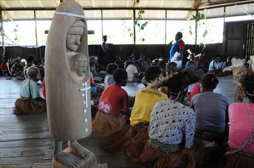 Activity in a simple church at Us village. Asmat carvings interpret the figure Mother Mary holding the baby Jesus in the imagination of an Asmat carver. The idea Asmat carving is very unique and original.