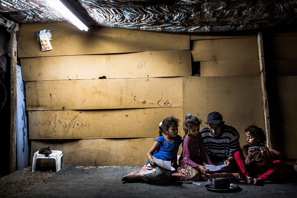 Abu Khamis helps his daughters with the Arabic homework for the next day. The family lives in one of the small villages that are at risk of demolition.
