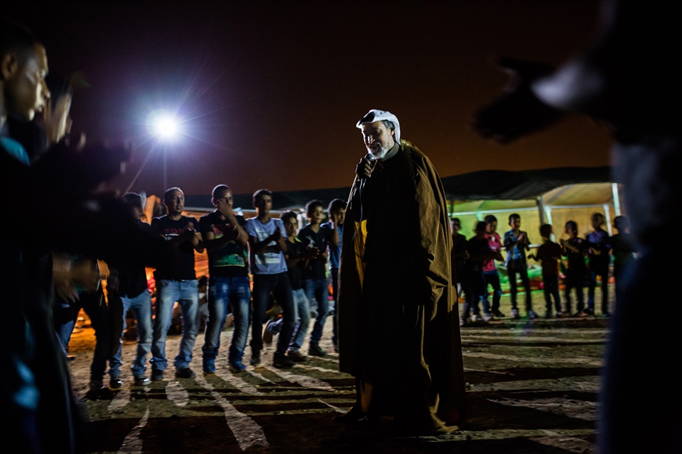 Friends and families participate in a traditional Bedouin dance during a wedding in one of the small Bedouin villages. A music system is rented from outside, a sheep has been slaughtered and water is constantly being boiled for coffee and tea. The women celebrate in a separate tent in the opposite end of the village. Despite their vulnerable situation, the Bedouins keep the spirit high.
