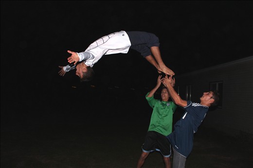 Aiming High: young men show off their acrobatic skills for a young female visitor to their countryside home.